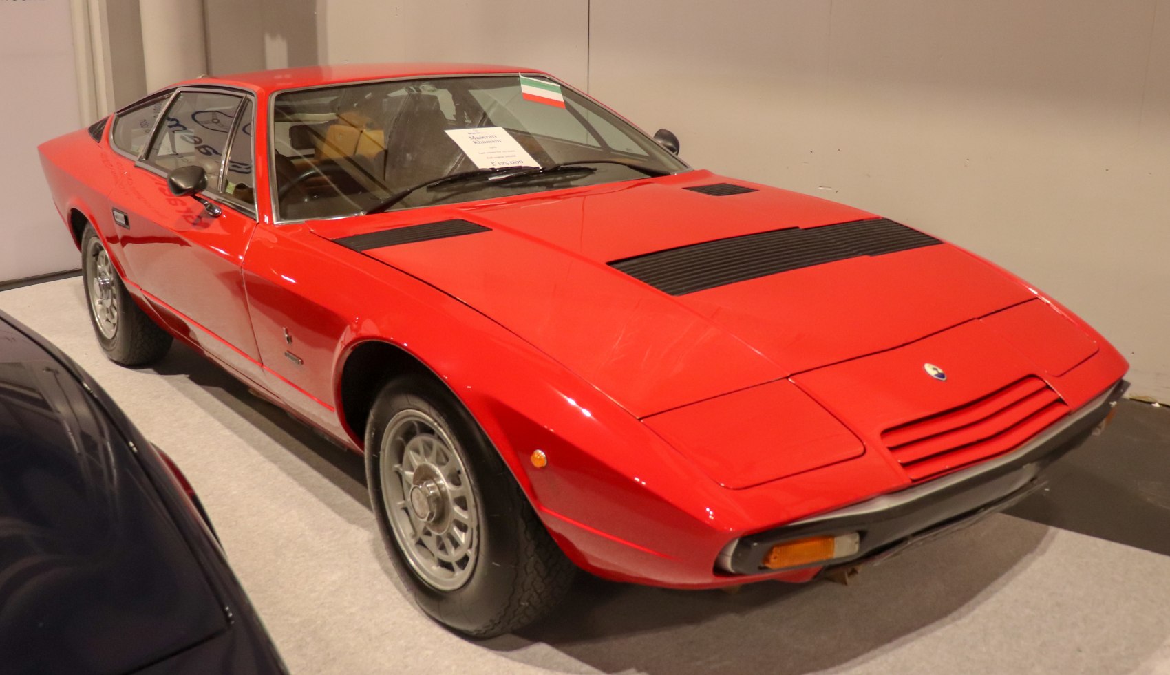 Red vintage sports coupe with angular design and front vent grille