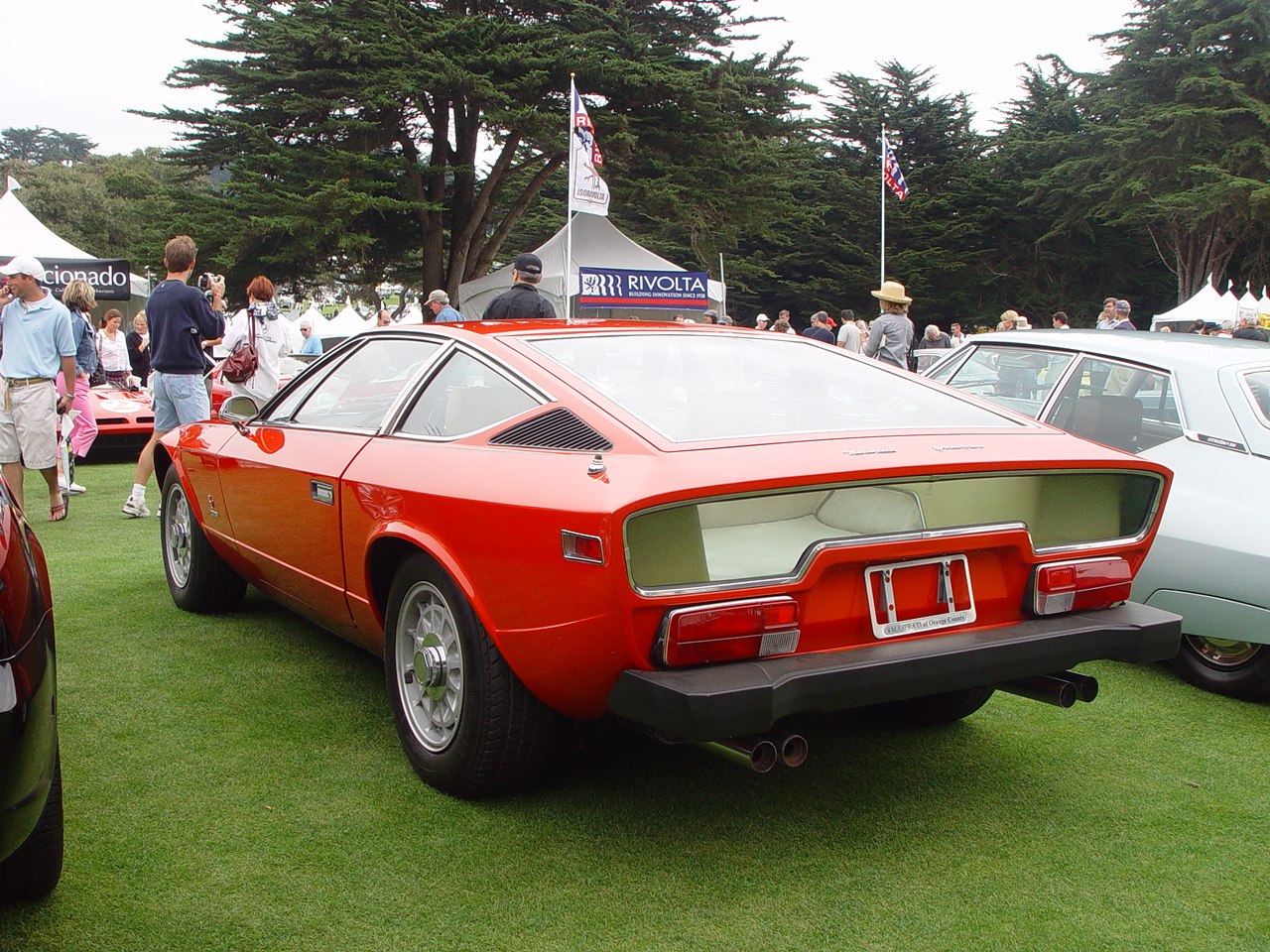 Angular rear taillights and dual exhaust pipes on a classic red sports coupe