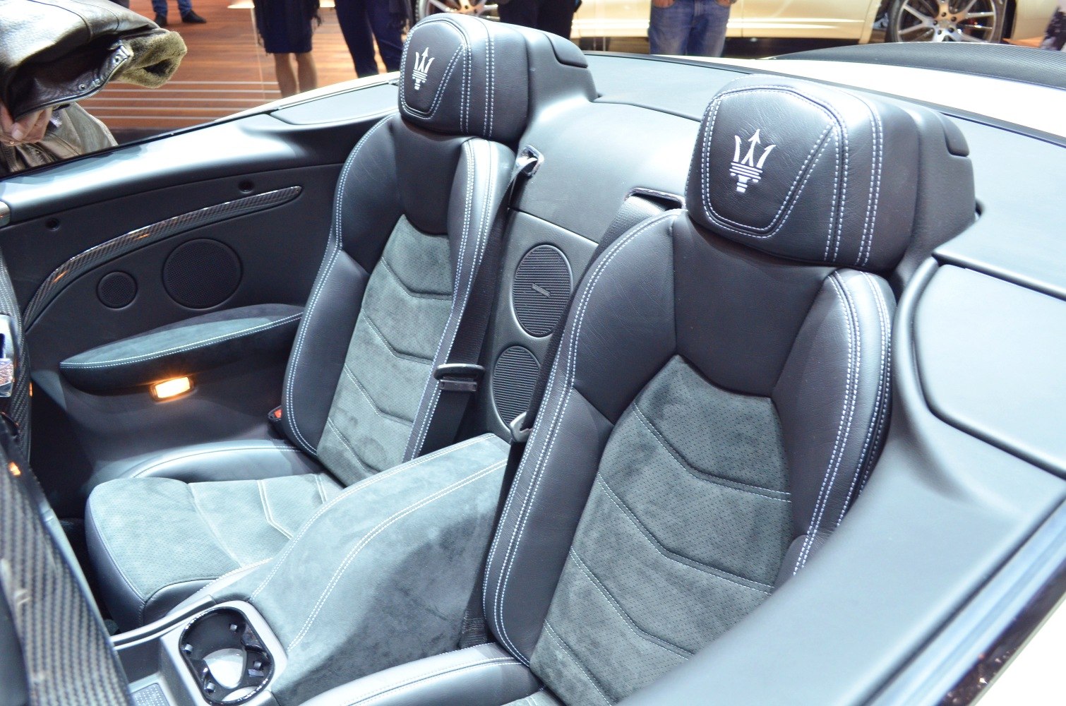 Dual black leather seats with white stitching and Maserati emblem on headrests