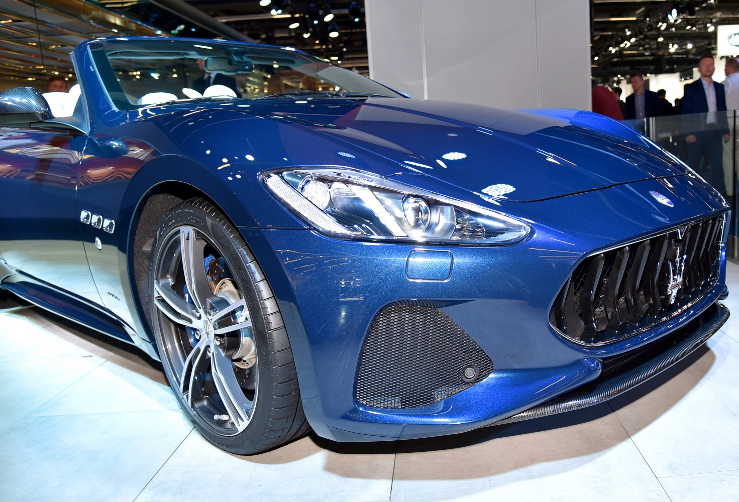 Close-up of sleek front grille and alloy wheel of a blue convertible
