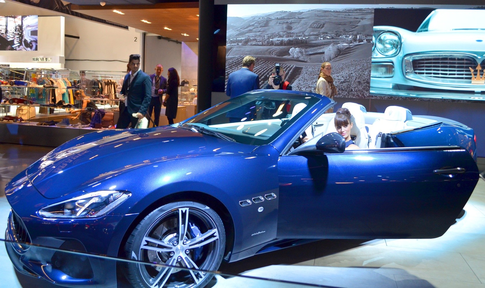 Blue convertible sports car with white leather interior and distinctive alloy wheels