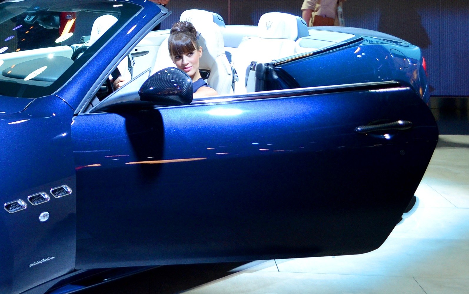 Open convertible door with white leather seats and carbon fiber mirror