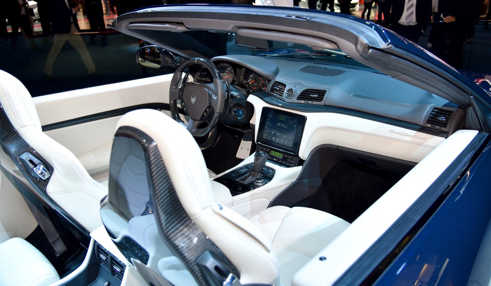 Luxury convertible interior with white leather and carbon fiber trim