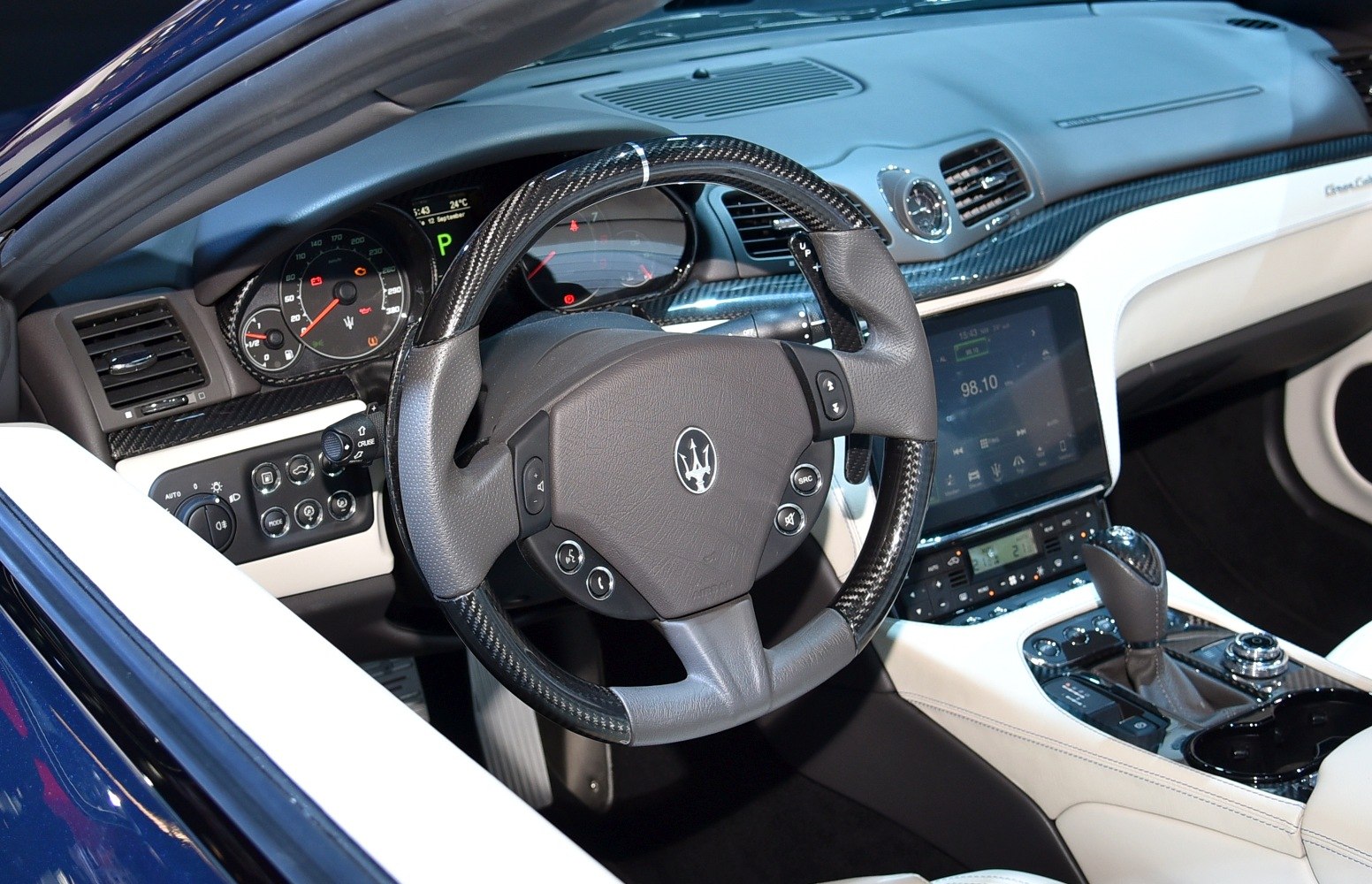 Carbon fiber and leather steering wheel with modern dashboard.