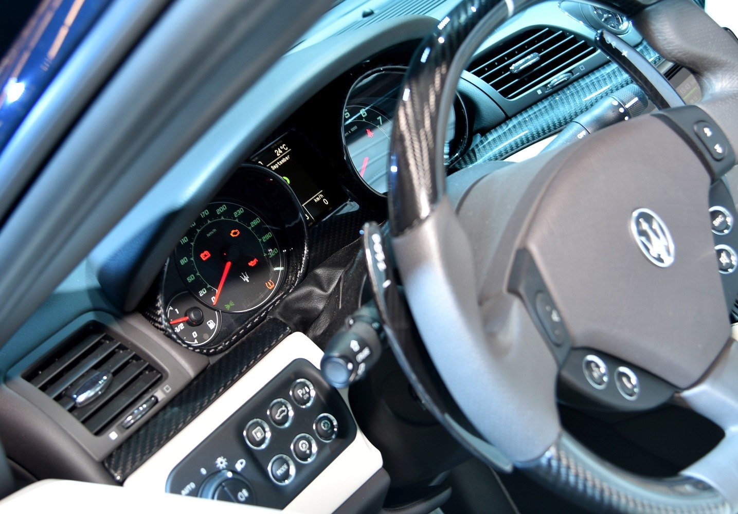 Luxury sports car dashboard and steering wheel with carbon fiber trim