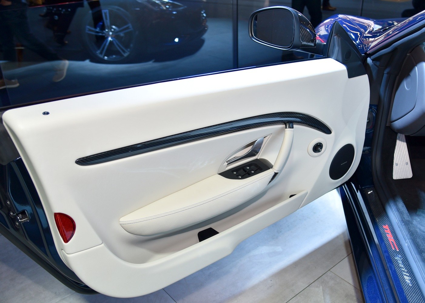 Light upholstery interior door panel with carbon trim and window controls.
