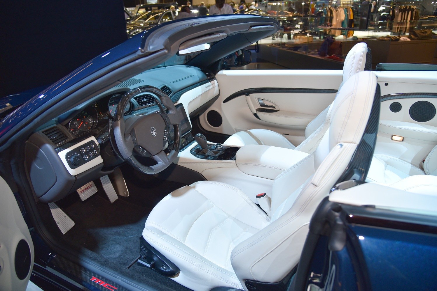 Luxury convertible interior with white leather seats and carbon fiber trim