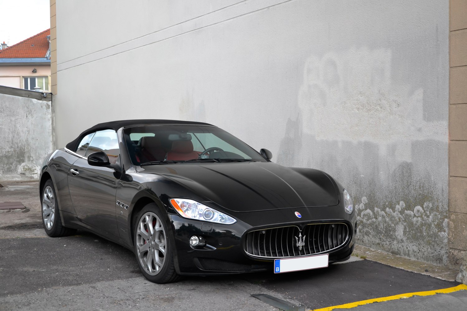 Front-side view of sleek convertible with distinct vertical grille and alloy wheels