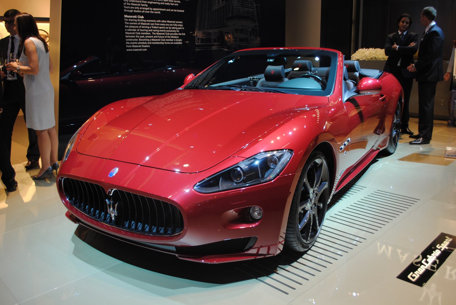 Red luxury convertible with prominent grille and sleek aerodynamic front end
