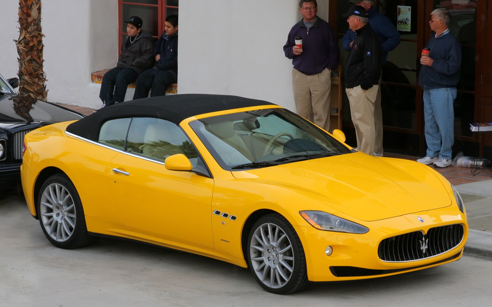 Yellow convertible with black soft top and prominent front grille