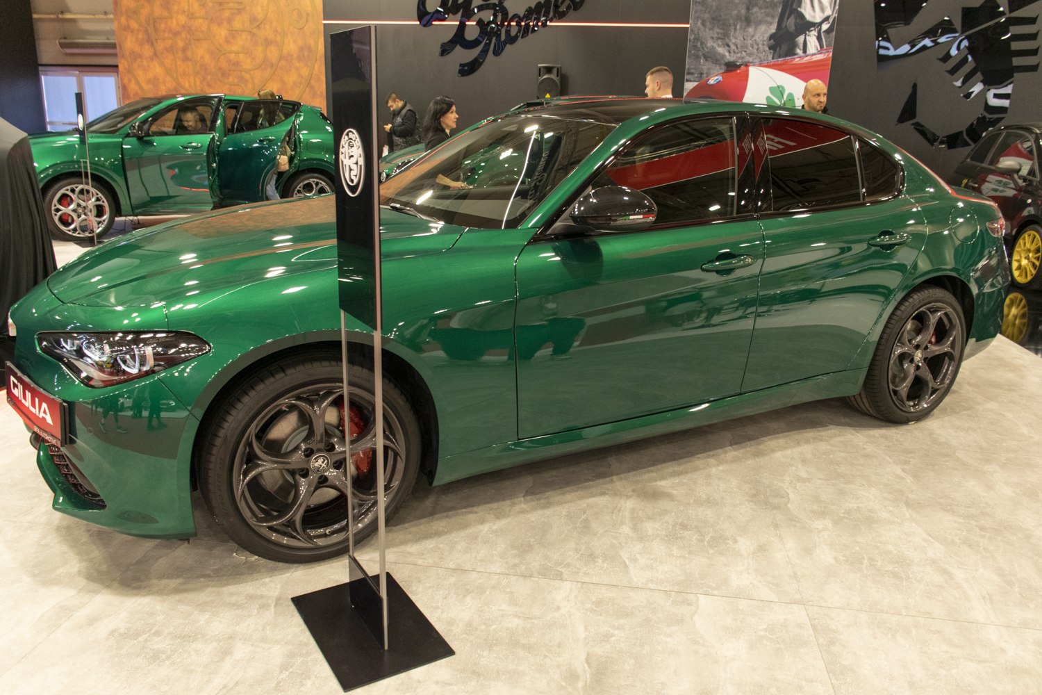 Side view of green luxury sedan with five-hole alloy wheels
