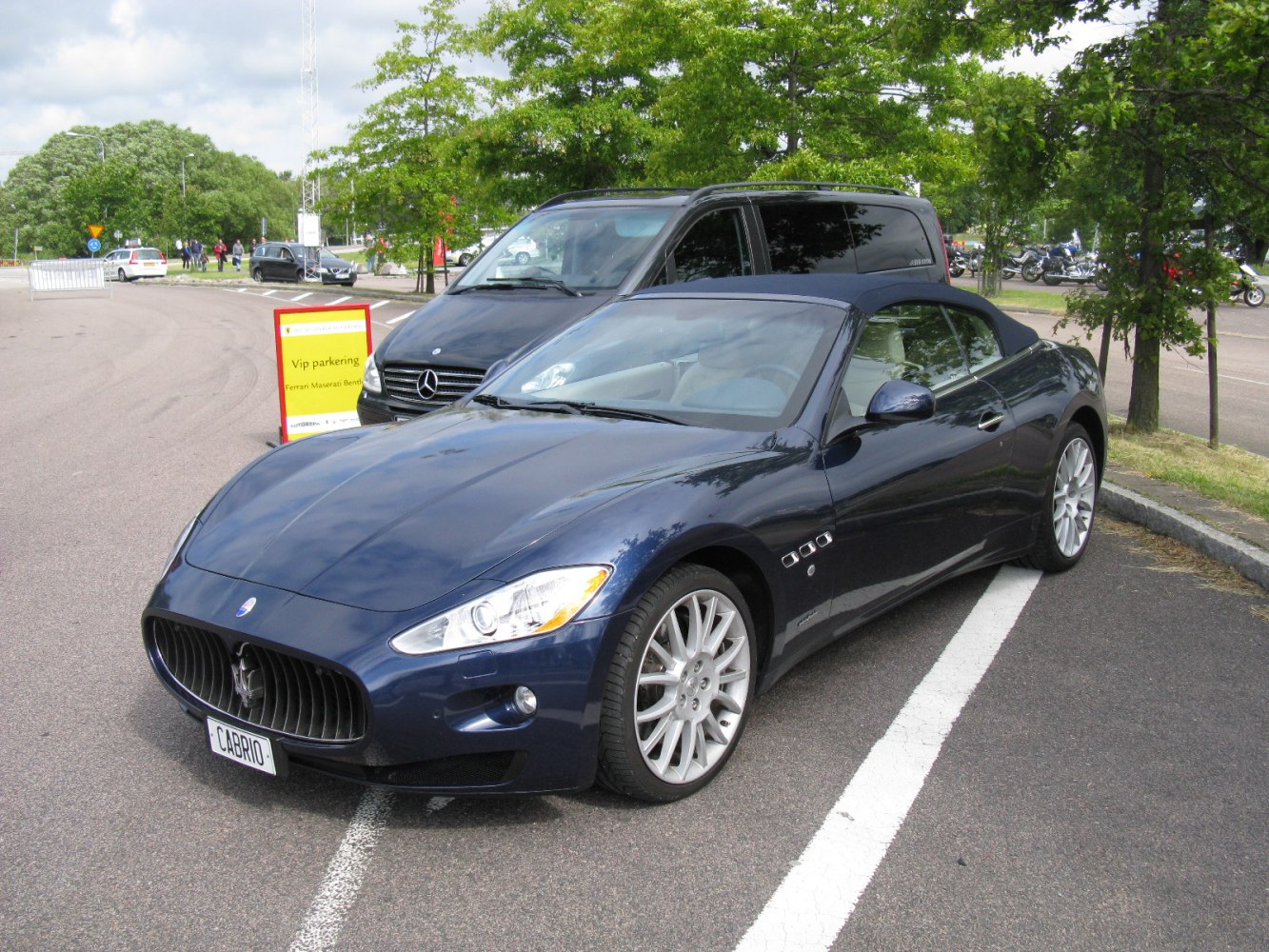 Convertible sports car with prominent front grille and multi-spoke alloy wheels