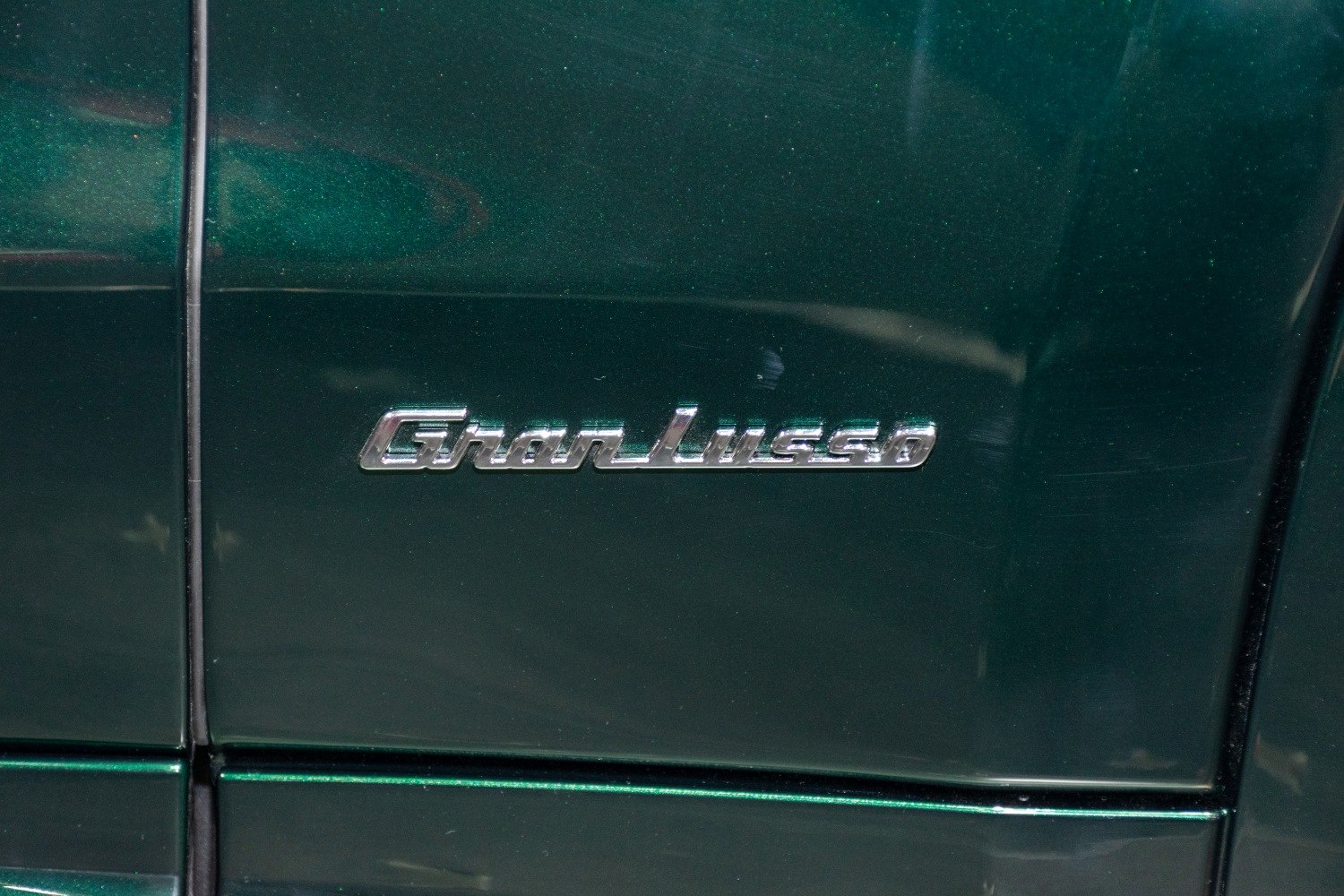 Close-up of GranLusso luxury trim badge on dark green vehicle panel