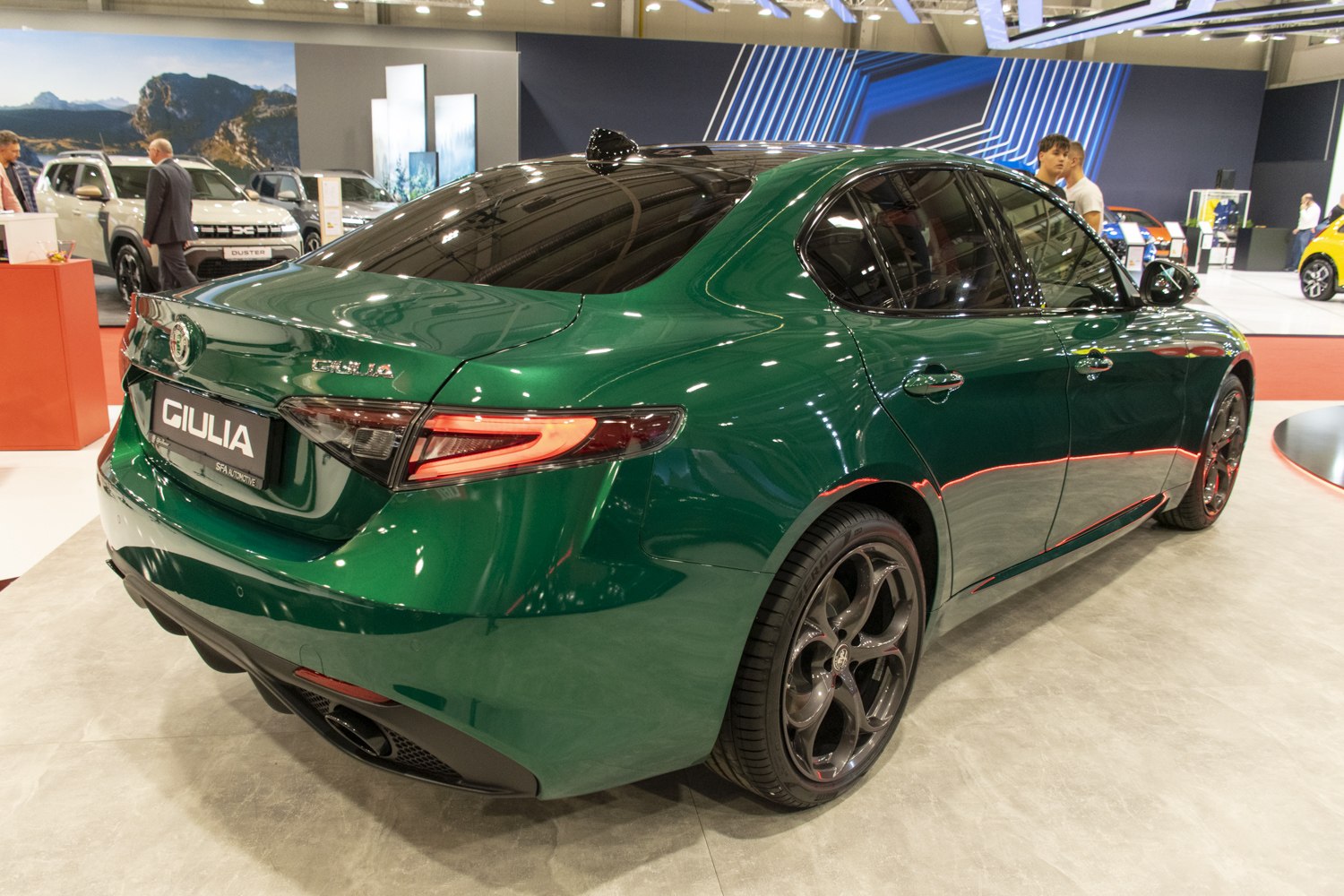 Rear and side view of a green sport sedan with tinted windows and black alloy wheels