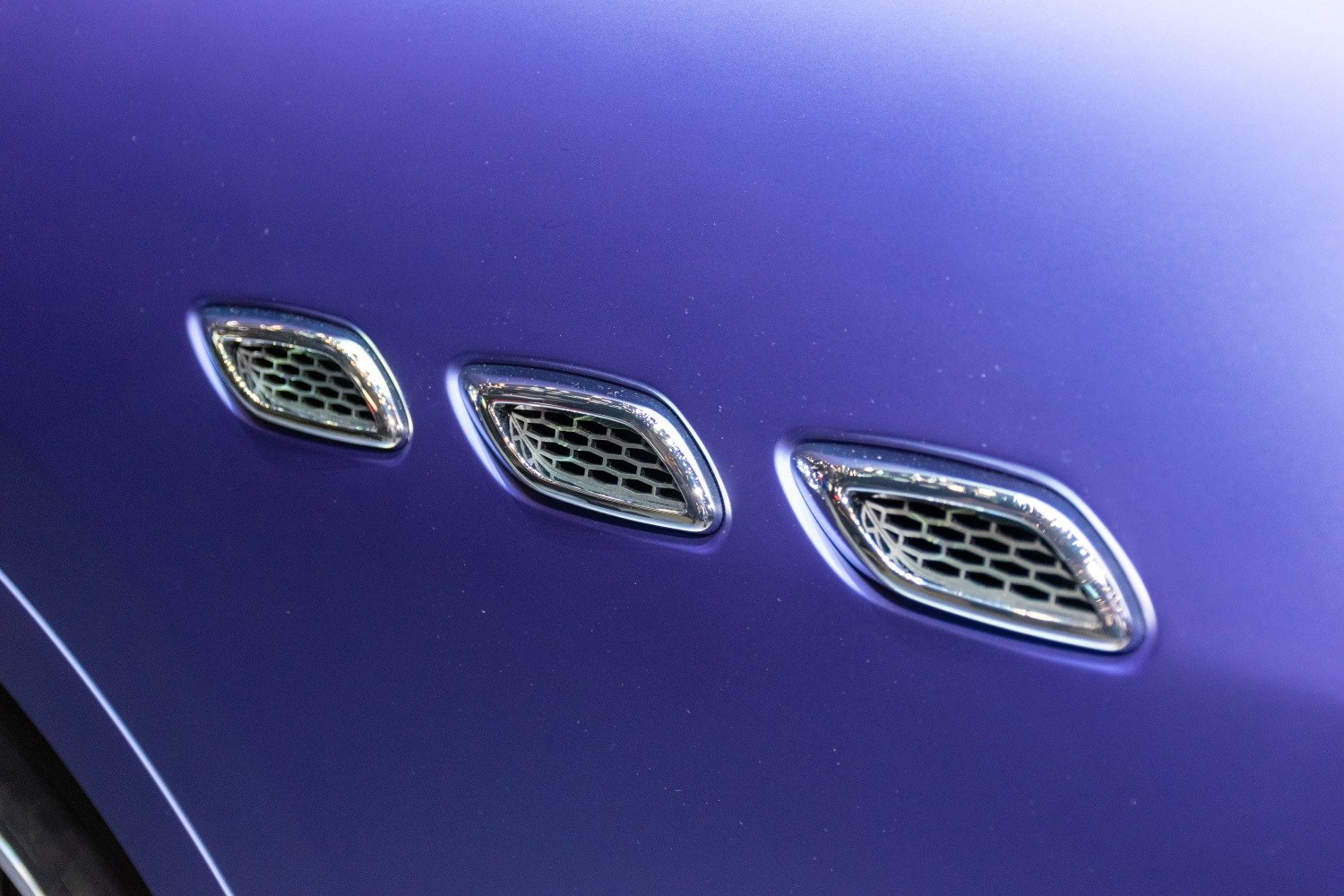 Tri chrome-trimmed side vents on car body