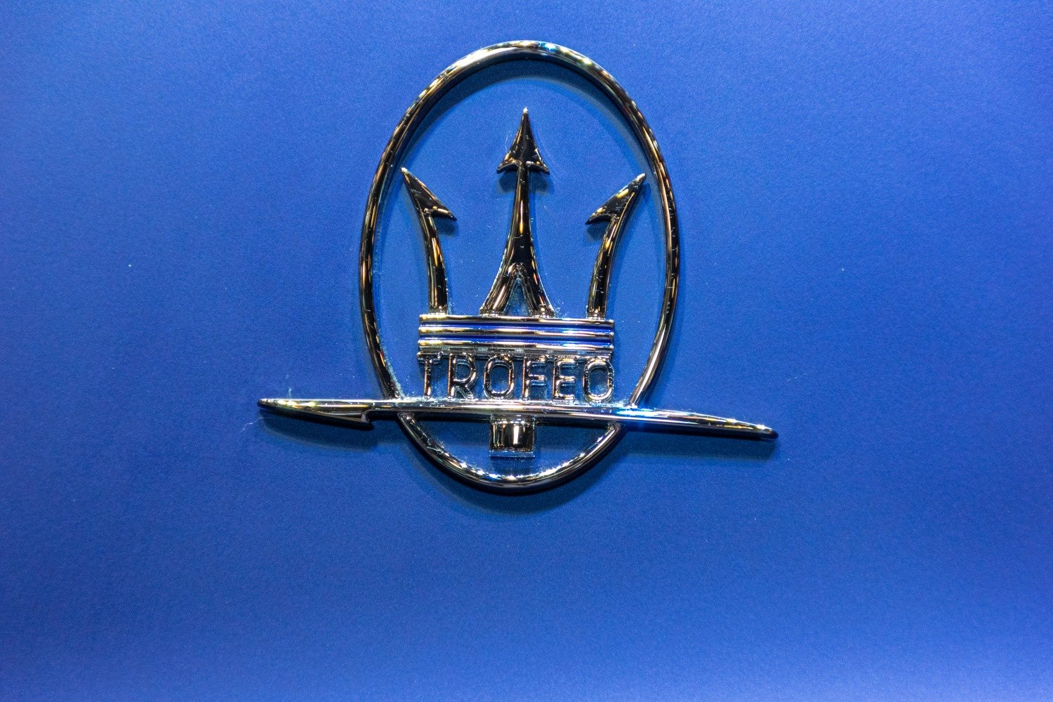 Chrome Maserati Levante Trofeo emblem on blue background