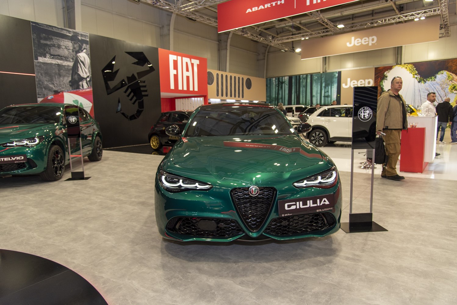 Front view of green luxury sports sedan with LED headlights and signature grille