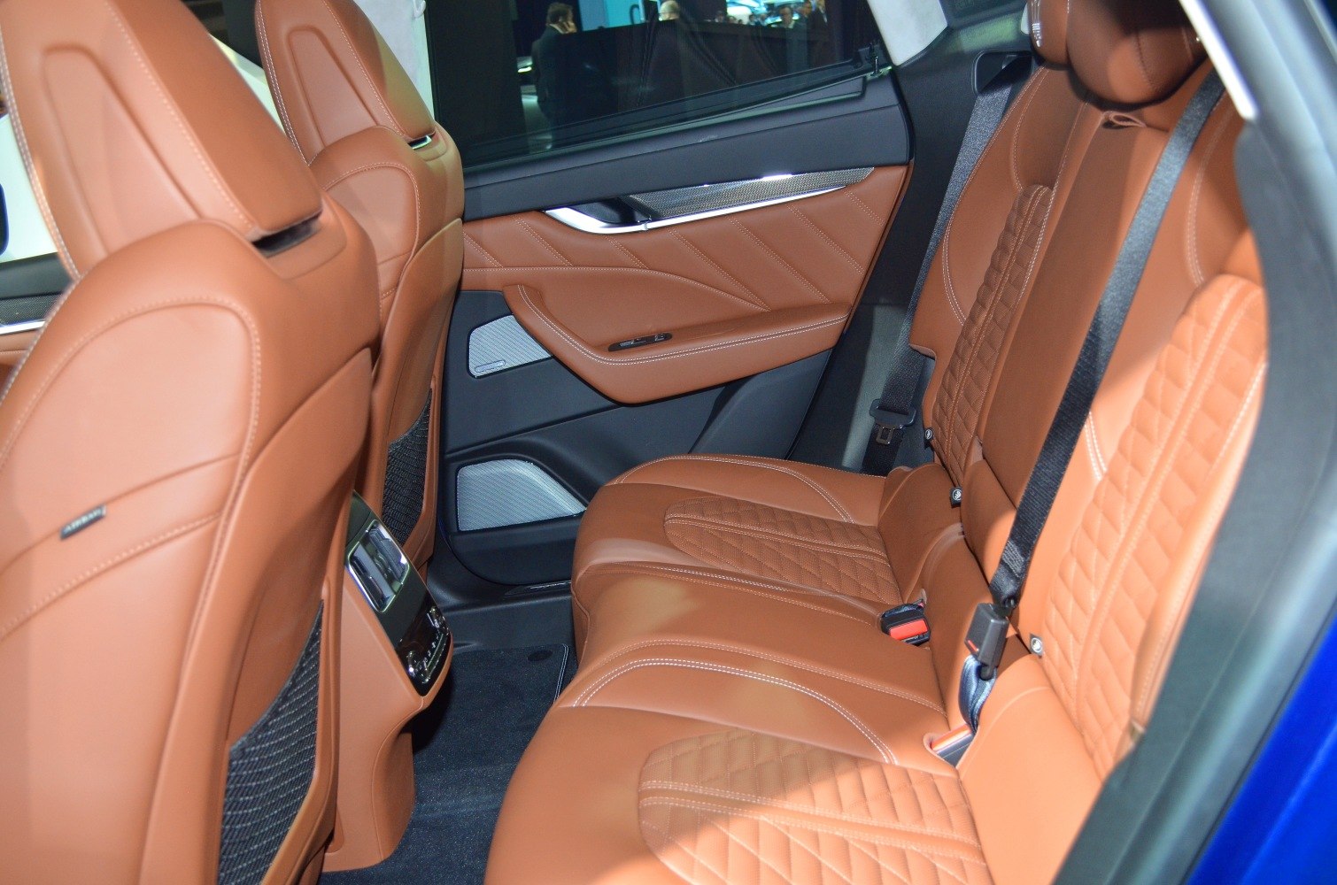 Brown leather rear seats with detailed stitching and comfort controls