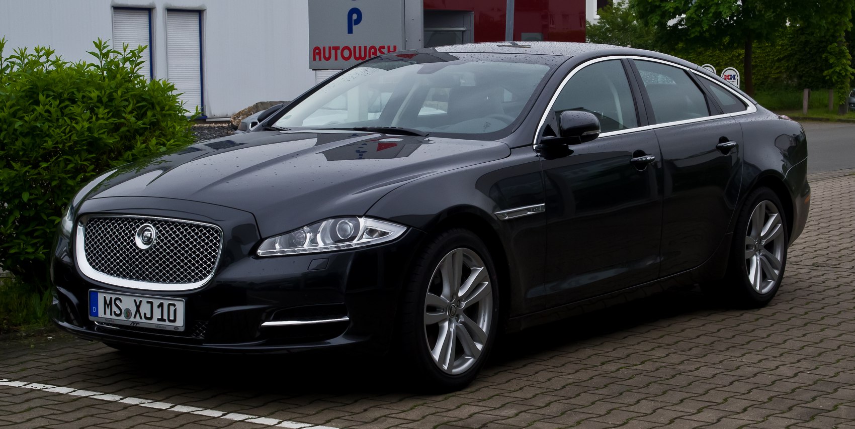 Front 3/4 view of luxury sedan with distinctive grille and headlights