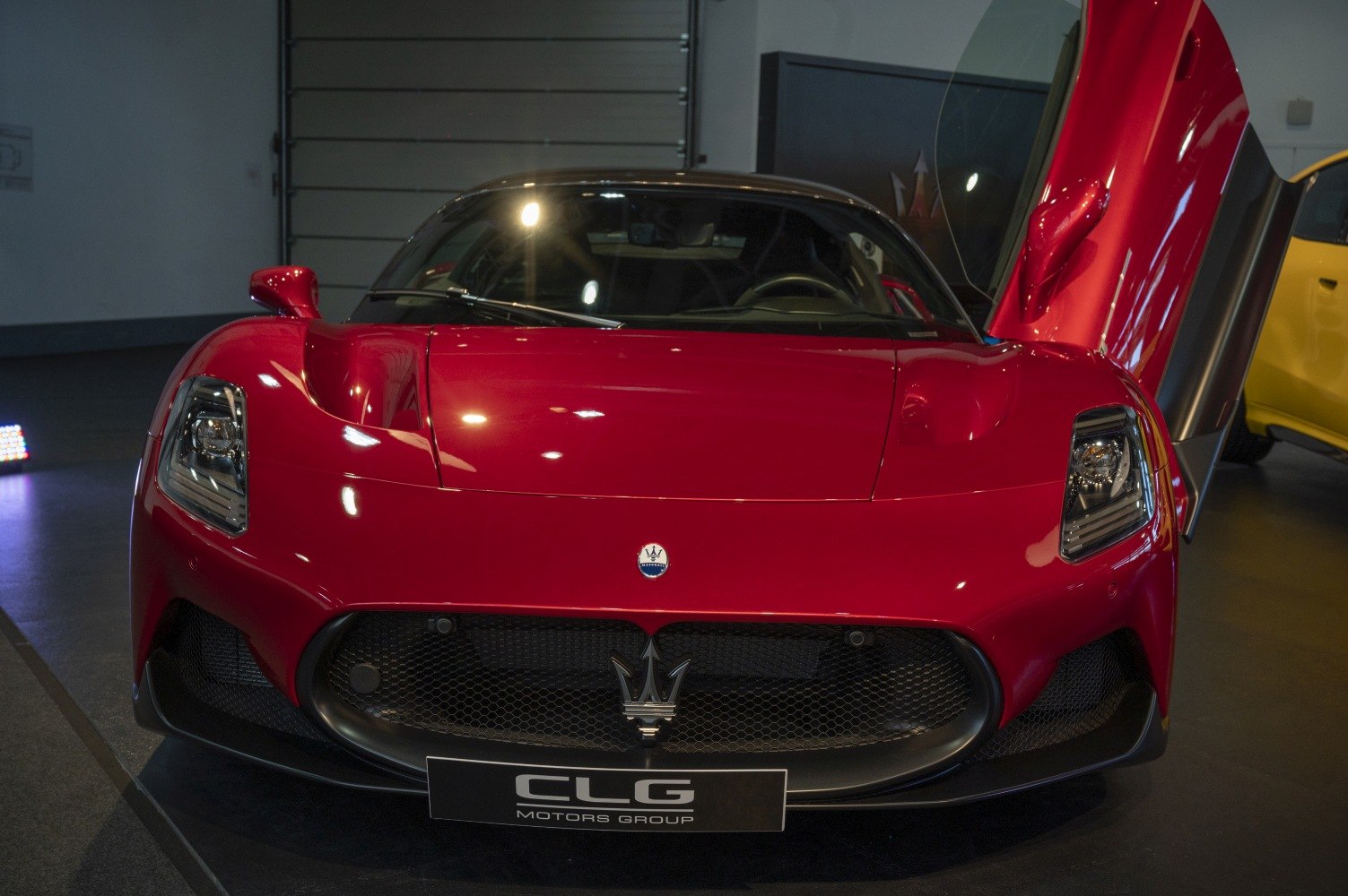 Sports car front with butterfly doors and bold grille.