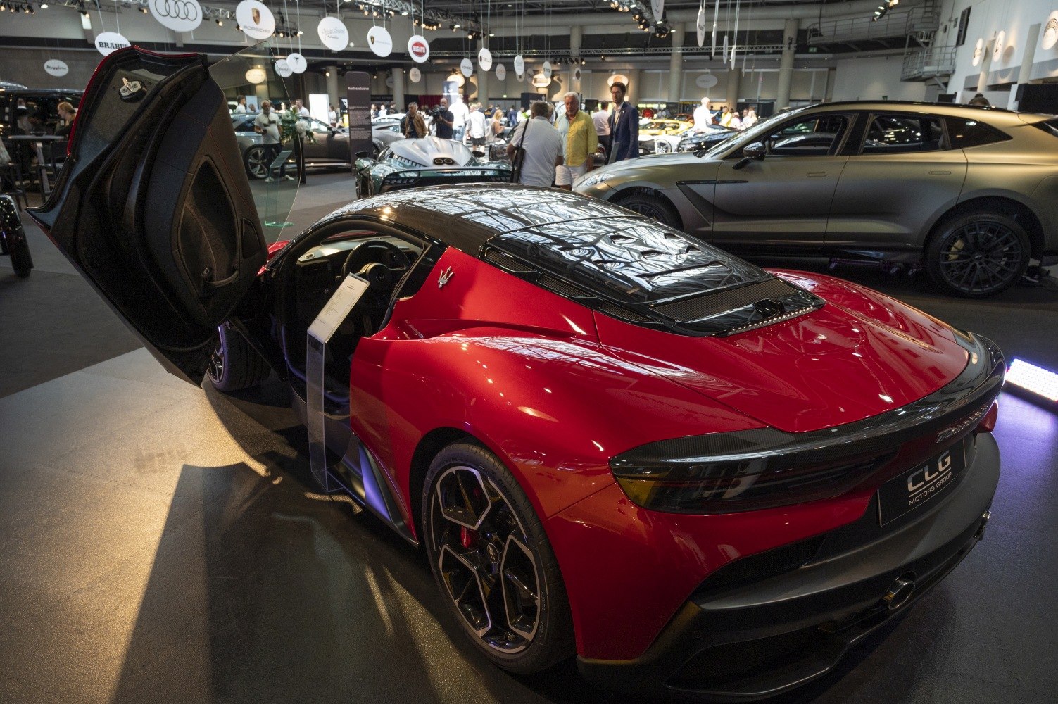 Mid-engine sports coupe with red body and scissor door open