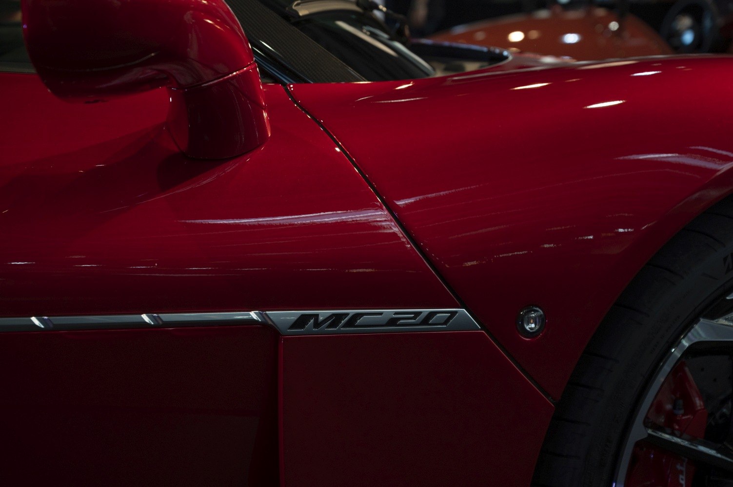 Close-up of MC20 side emblem, mirror, and front tire.