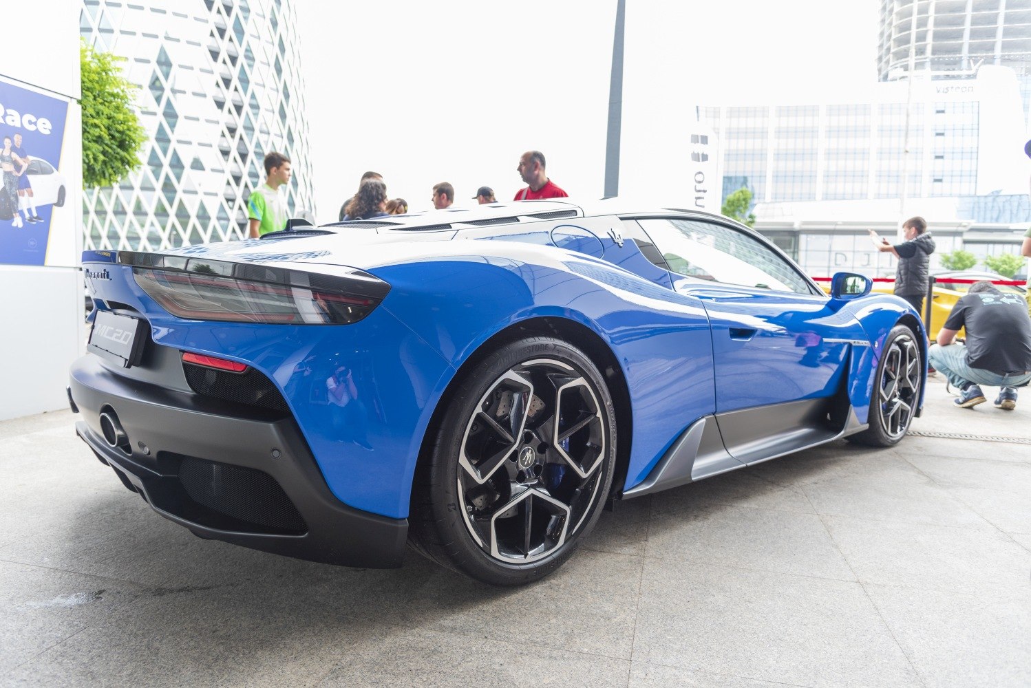 Rear view of blue sports car with unique wheel design and aerodynamic features
