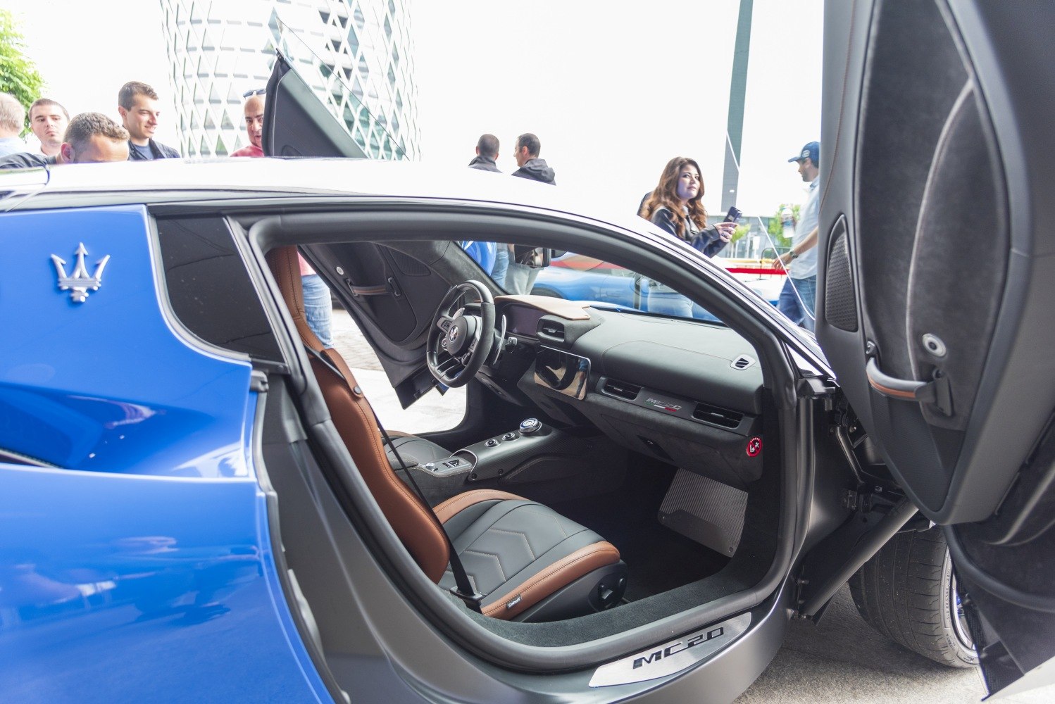 Butterfly doors open revealing sleek sports seats and modern dashboard.