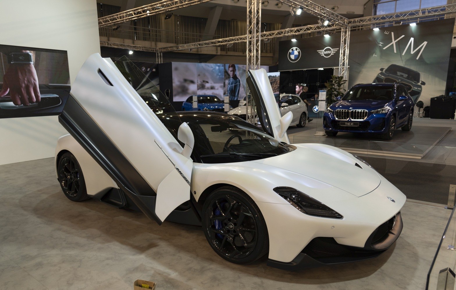 White sports car with upward-opening scissor doors and black wheels