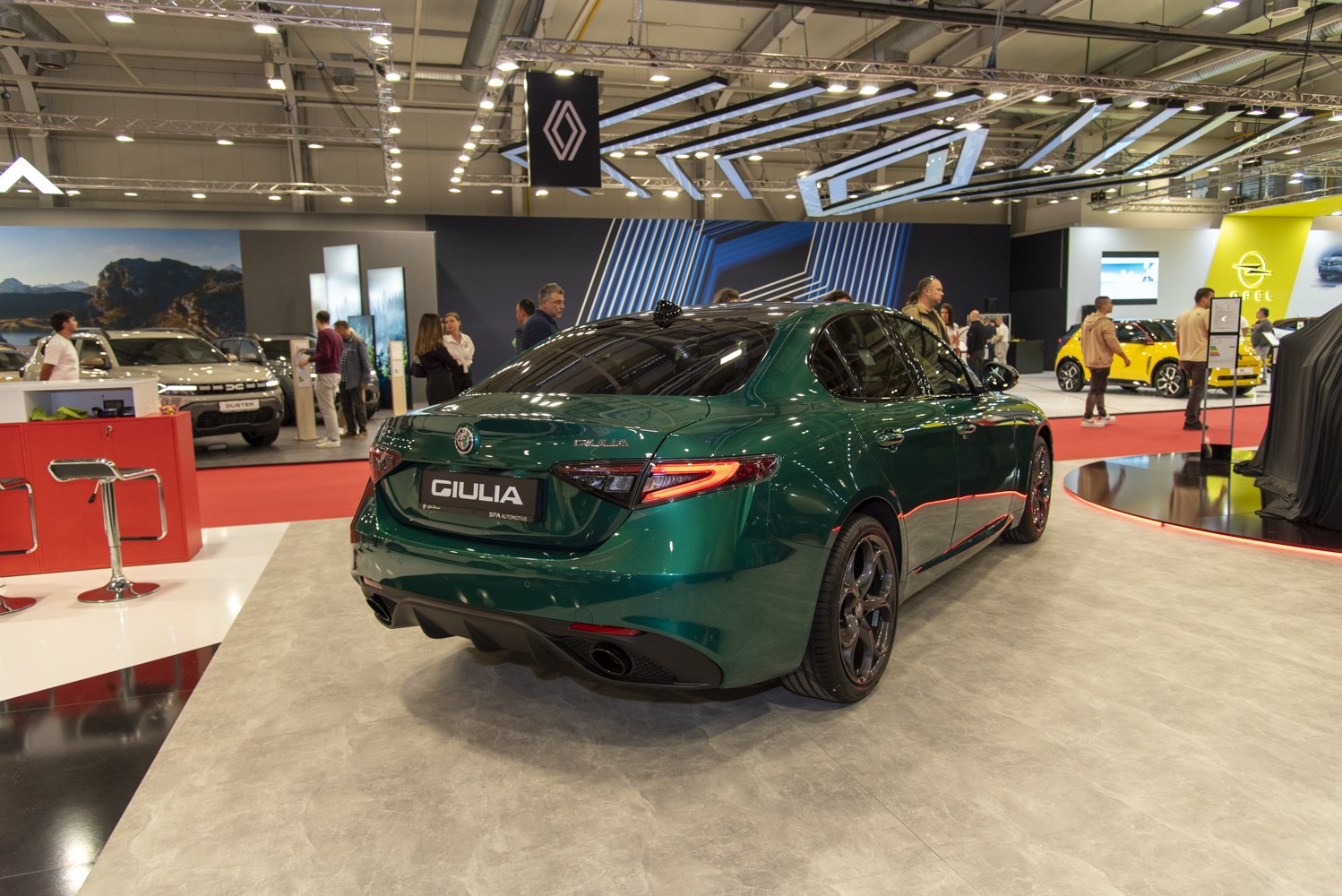Rear view of green sedan with distinctive tail lights and dual exhausts
