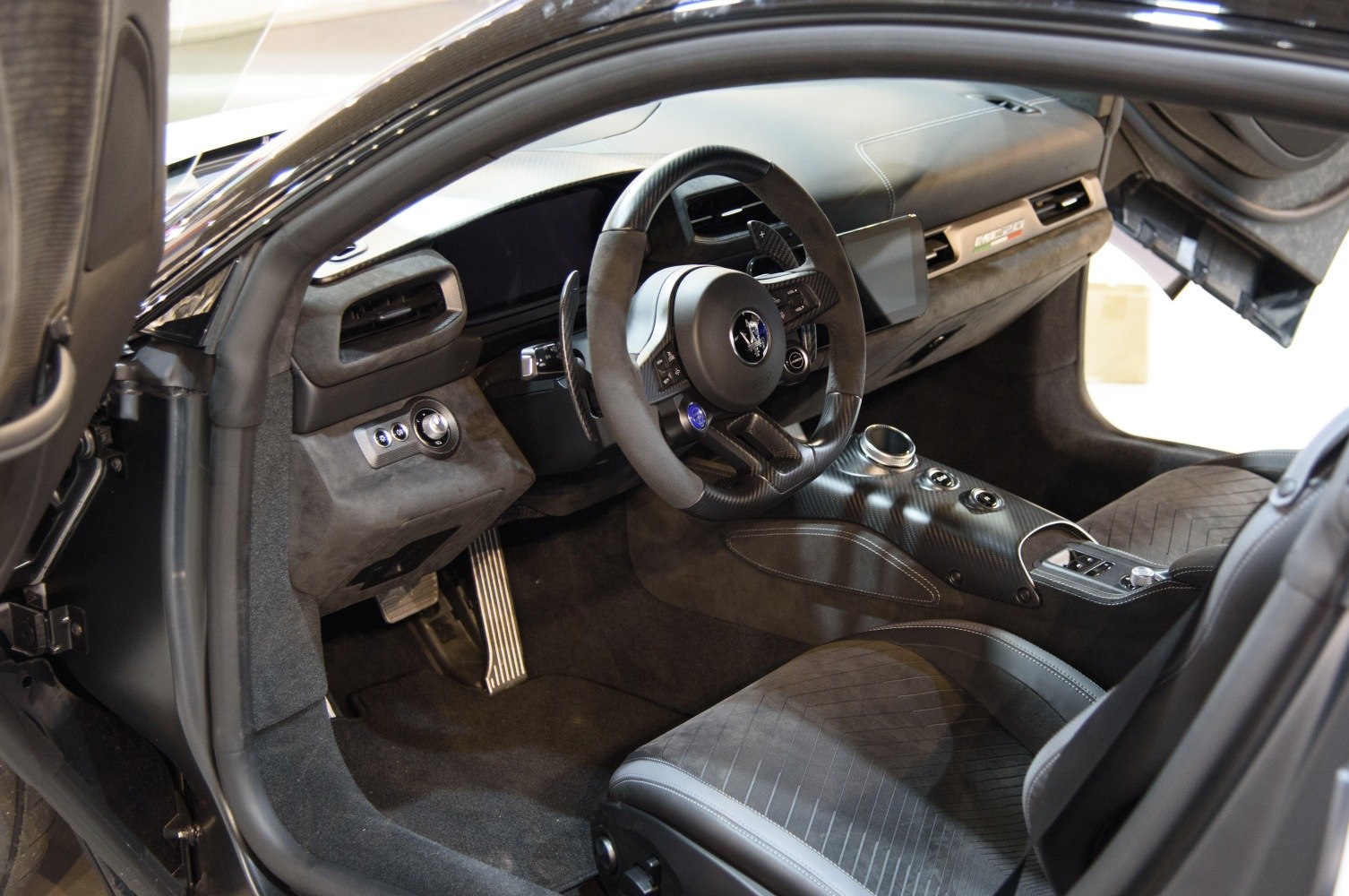 Carbon fiber steering wheel and modern digital dashboard with sporty seats