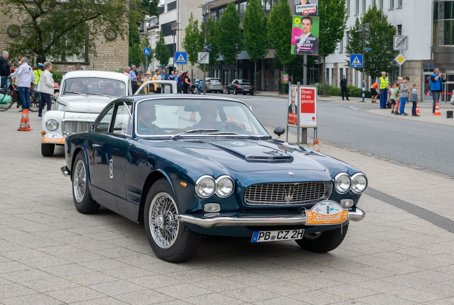 Classic sports coupe front view with wire-spoke wheels and quad headlights