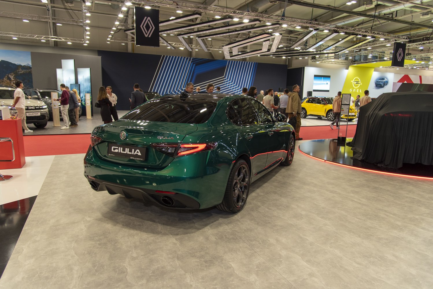 Rear view of a sleek sports sedan with distinctive taillights and green paint