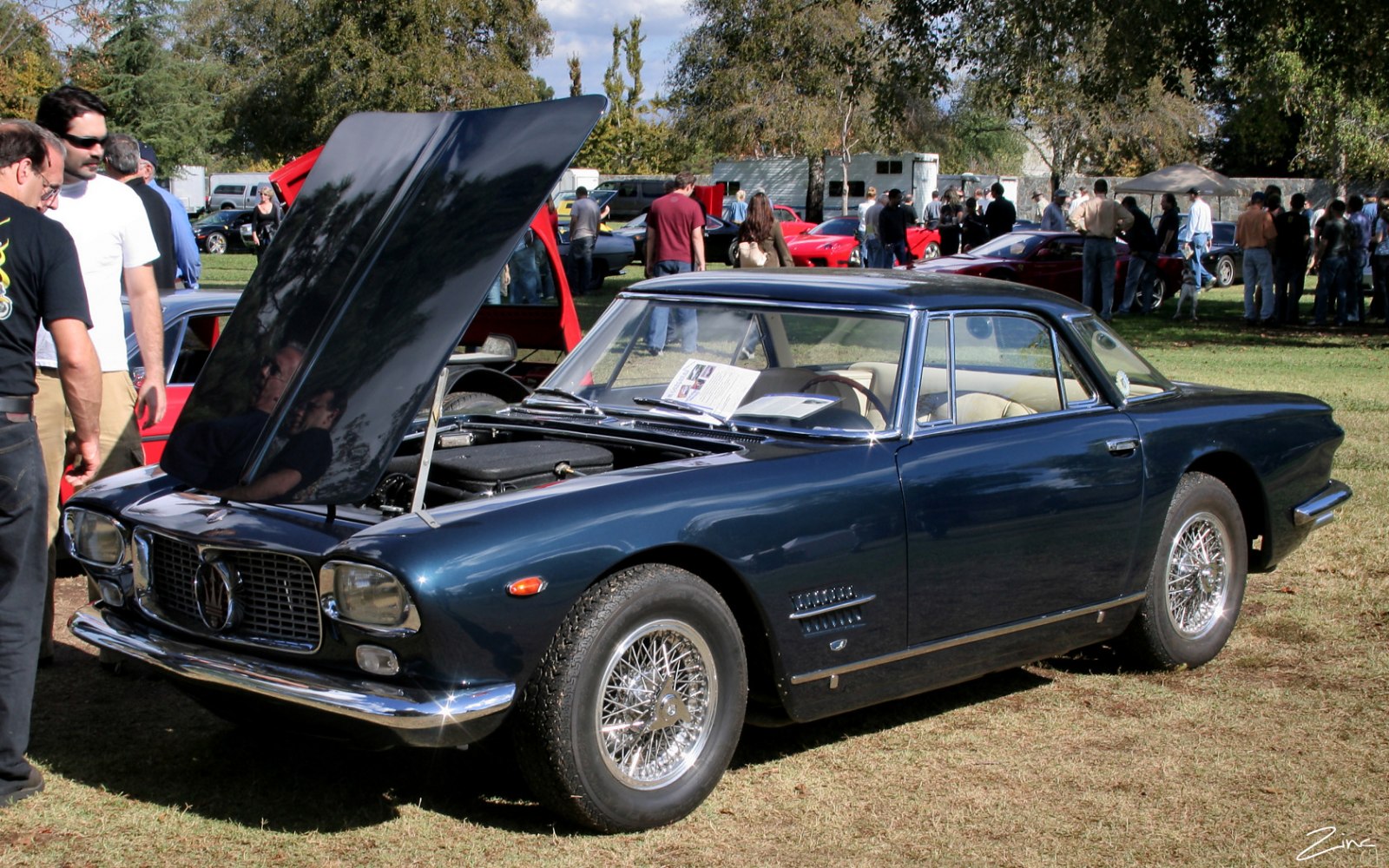 Classic car with open hood and wire-spoke wheels