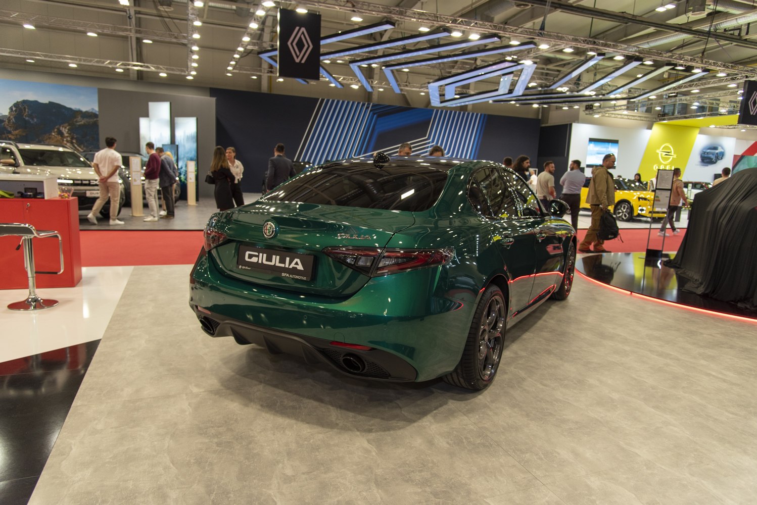 Rear view of green sedan showing twin exhausts and sporty design