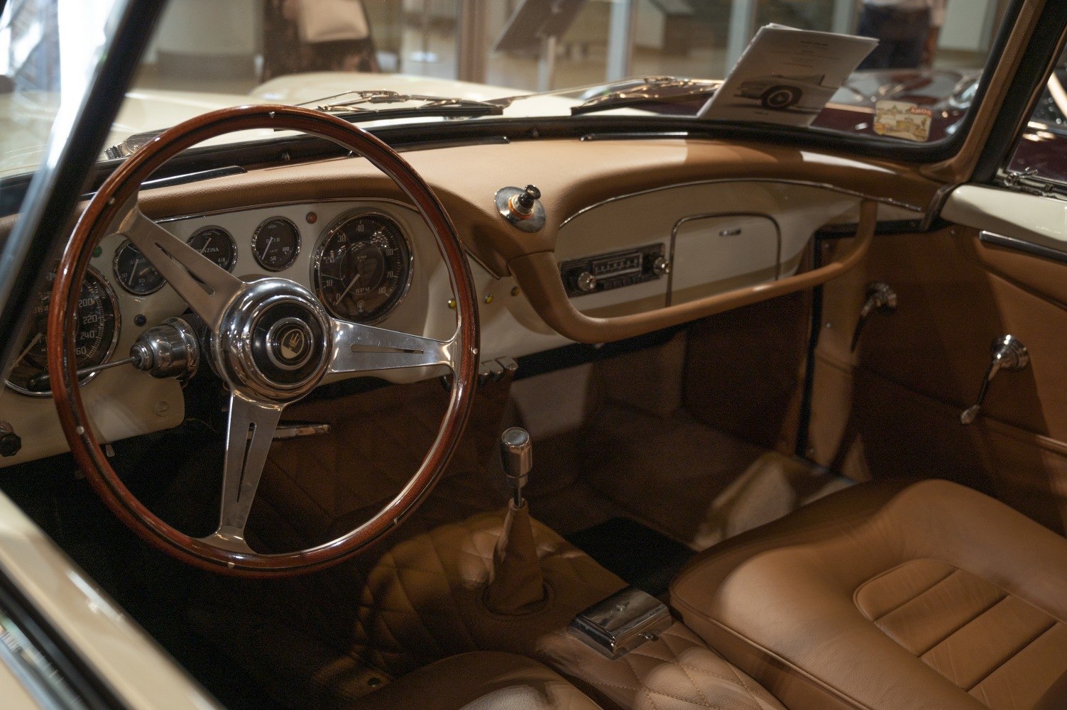 Classic vintage car interior with wood steering wheel and analog gauges