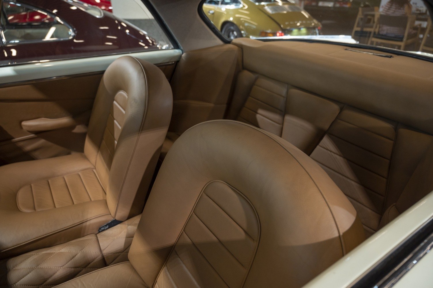 Vintage tan leather seats inside a classic car interior.