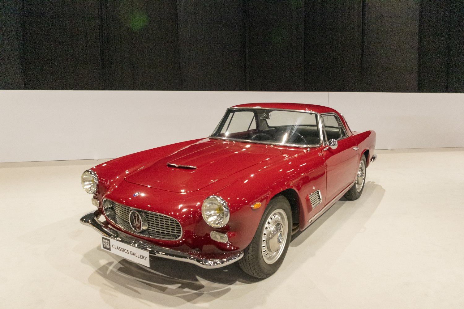 Front left side view of a vintage coupe with prominent headlights and grille