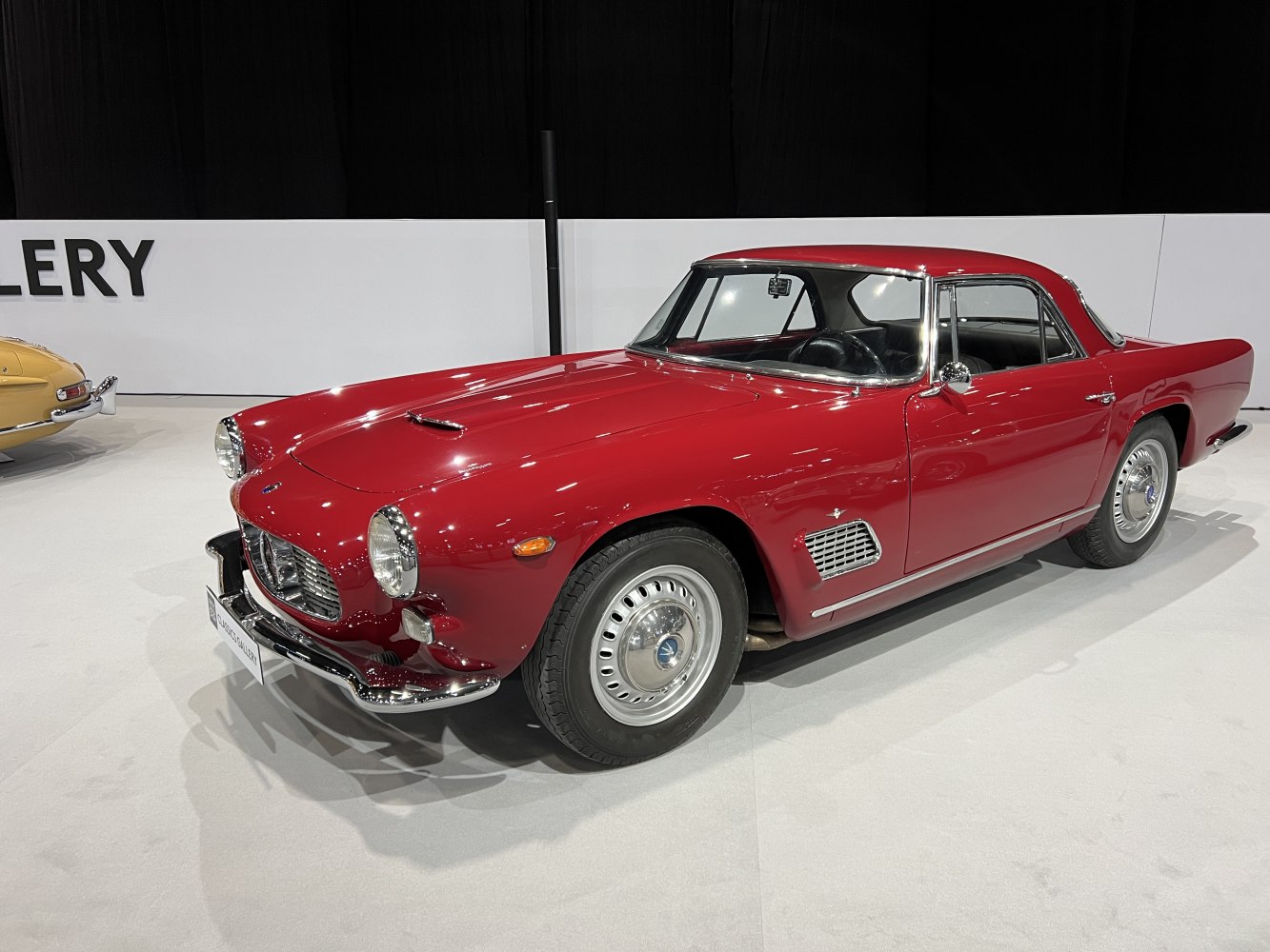 Red vintage coupe with classic grille and chrome accents