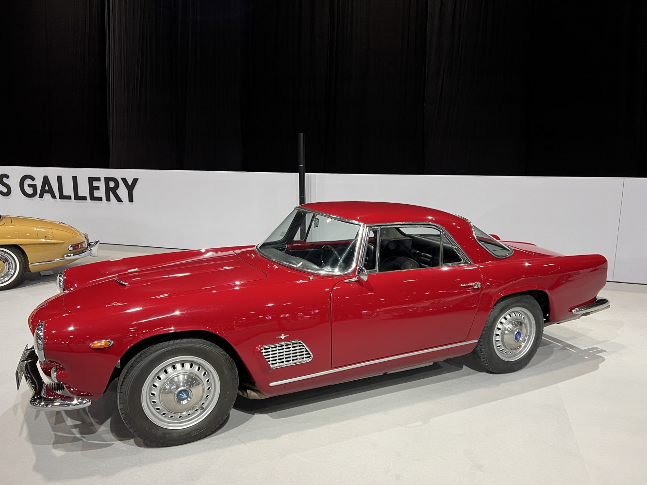 Red vintage coupe with sleek side profile and chrome details