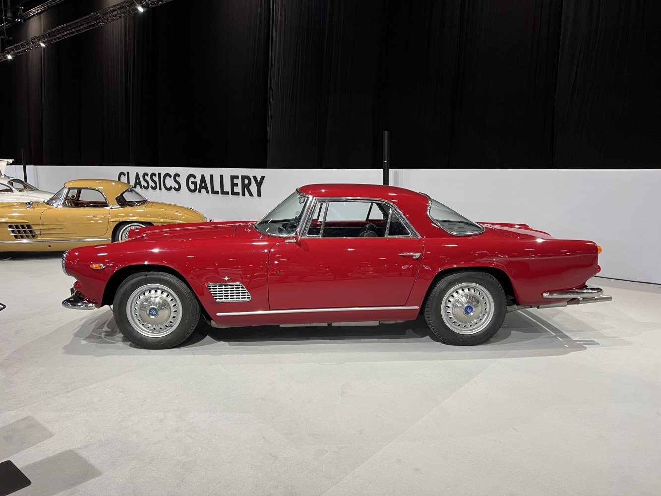 Red vintage coupe with chrome bumper and wire-spoke wheels