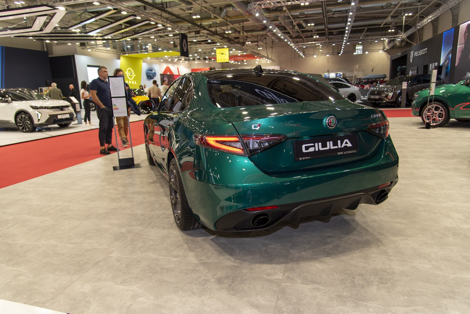 Rear view of a green sedan with signature taillights and dual exhausts