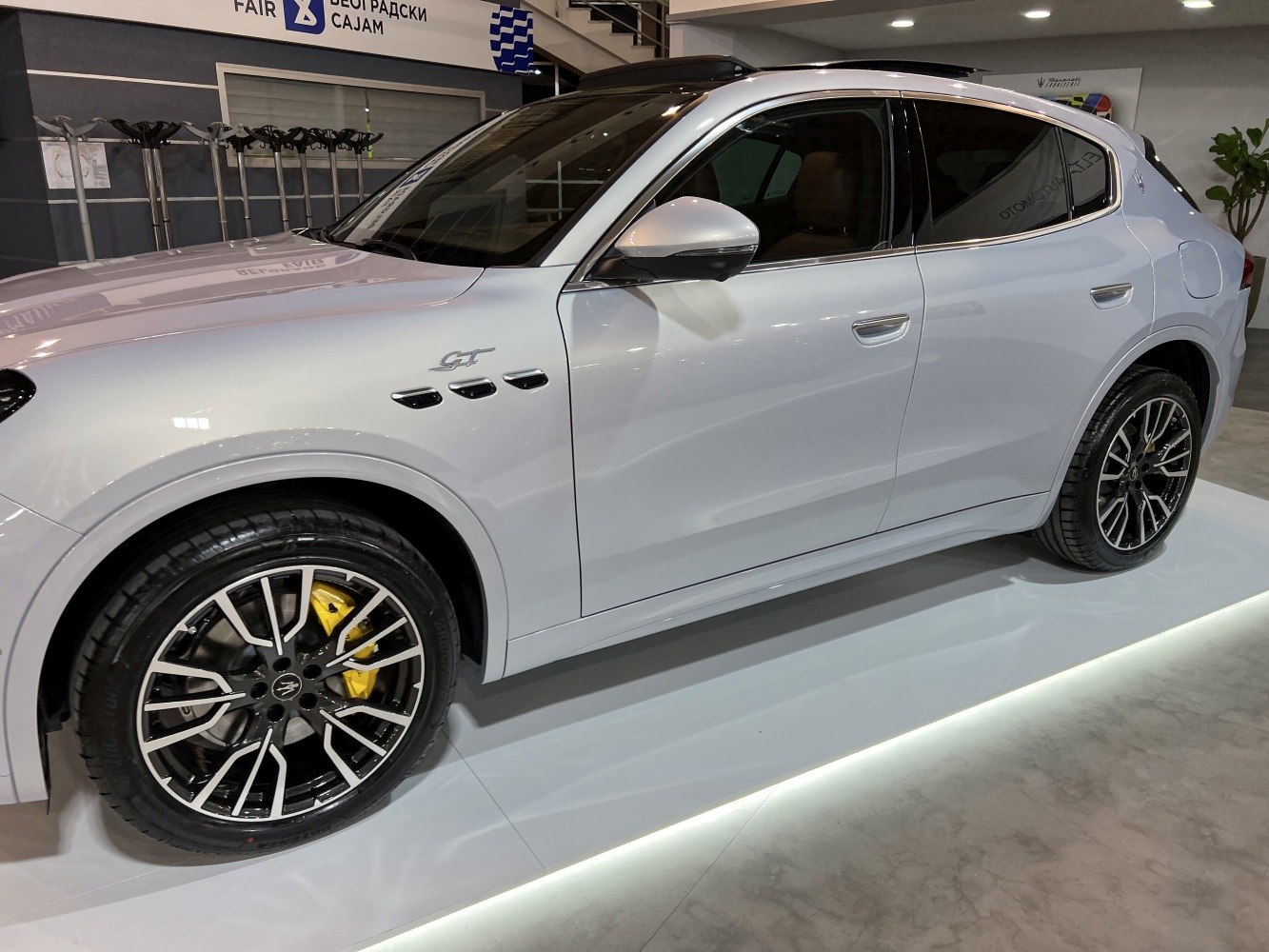 Side profile of a white SUV with black-silver alloy wheels and yellow brake calipers
