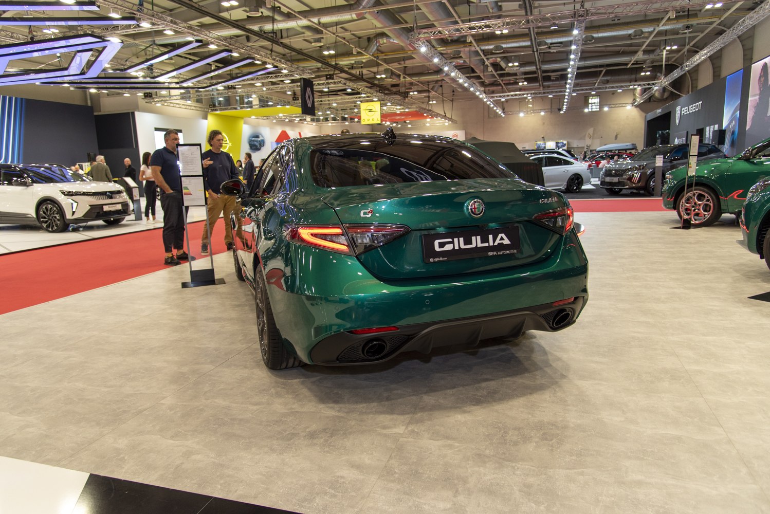 Green sports sedan rear view with distinctive taillights and dual exhaust