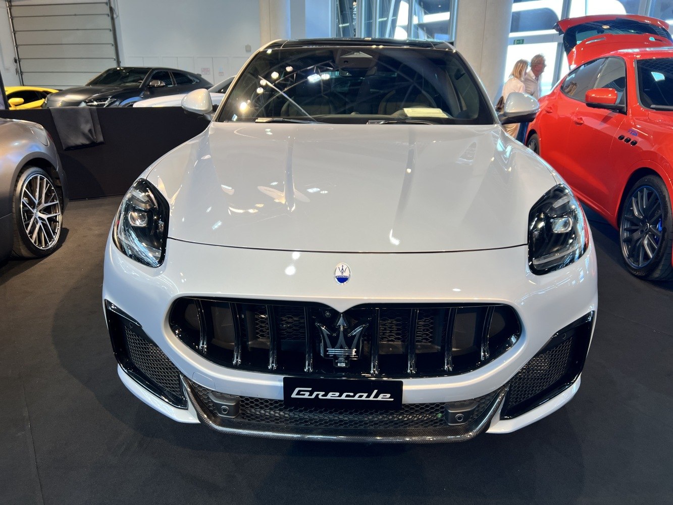 Wide front grille and sleek headlights on a luxury SUV frontal view