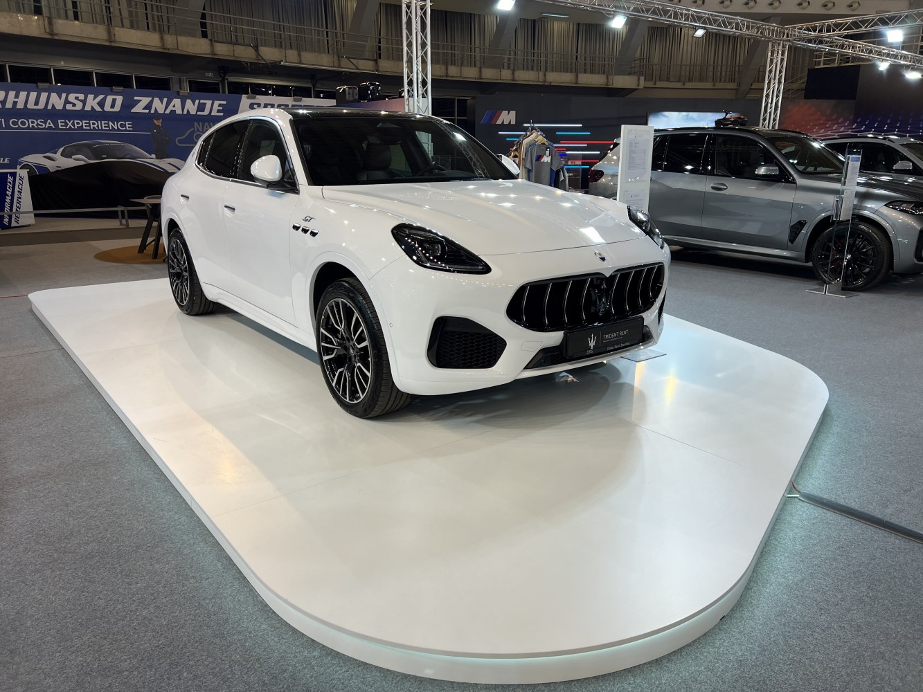 White luxury SUV with bold front grille and sporty alloy wheels.