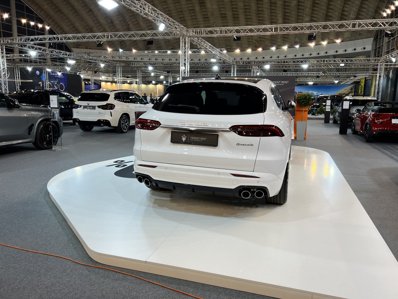 Rear view of white SUV with quad exhaust pipes and sleek taillights