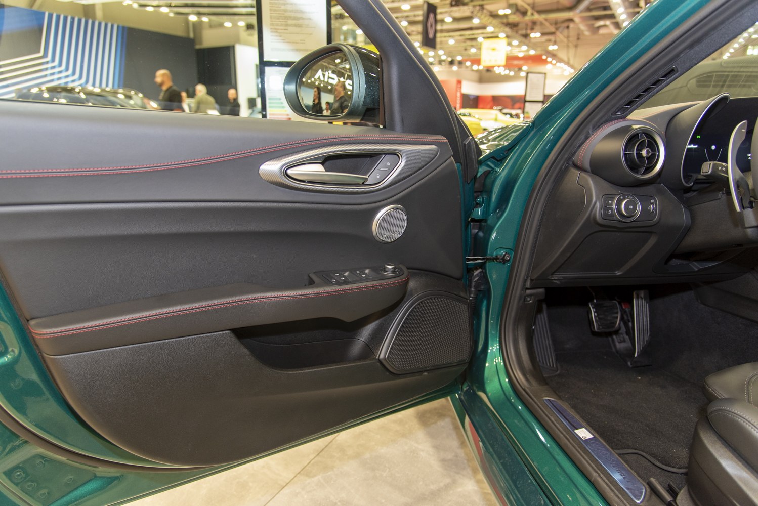 Interior driver door panel with controls and red stitching