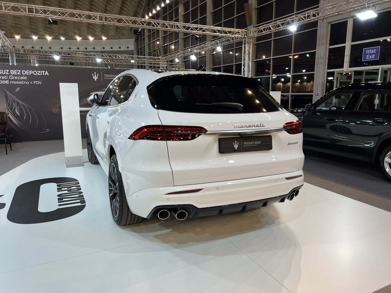Rear view of a sleek luxury SUV with quad exhaust pipes and modern tail lights.