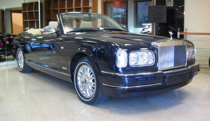 Front-side view of a luxury convertible with distinctive grille and chrome wheels